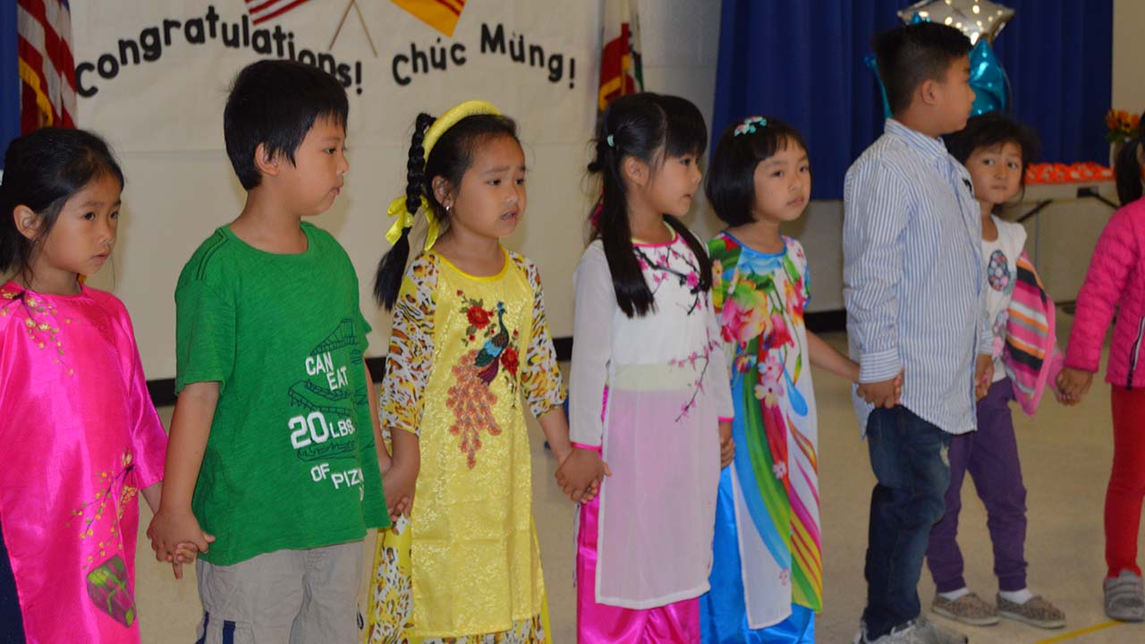 students standing in a simi-circle holding hands